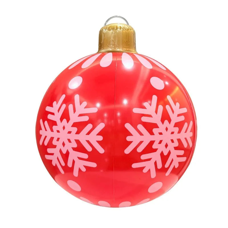 Large red and white inflatable Christmas ball with flashing lights standing in a garden.