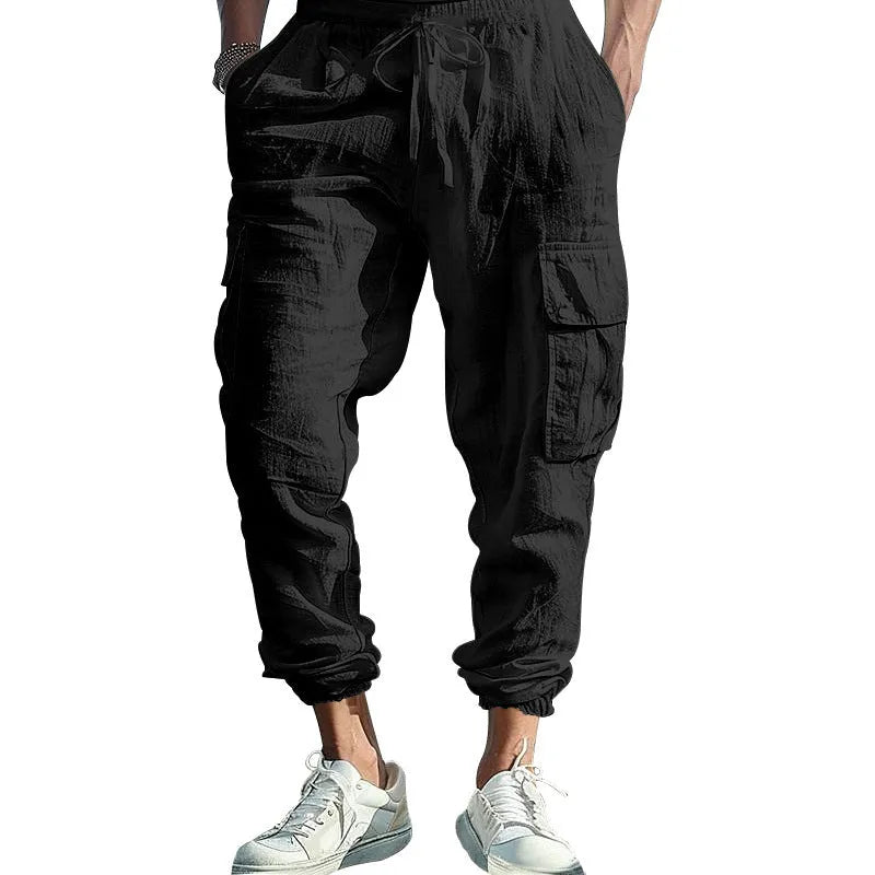 Man wearing khaki linen casual trousers with ankle-tied cuffs and multiple pockets.
