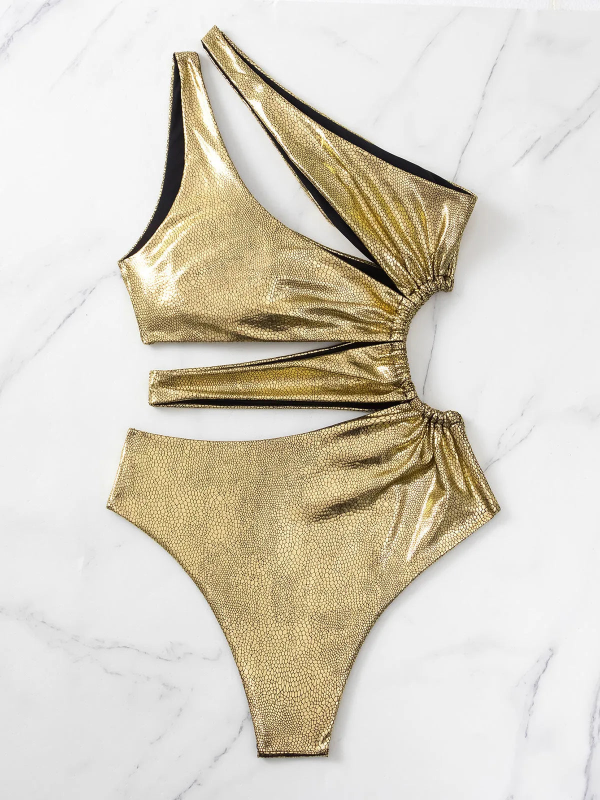Gold women's backless one-piece swimsuit on a neutral background, showing sleeveless design.