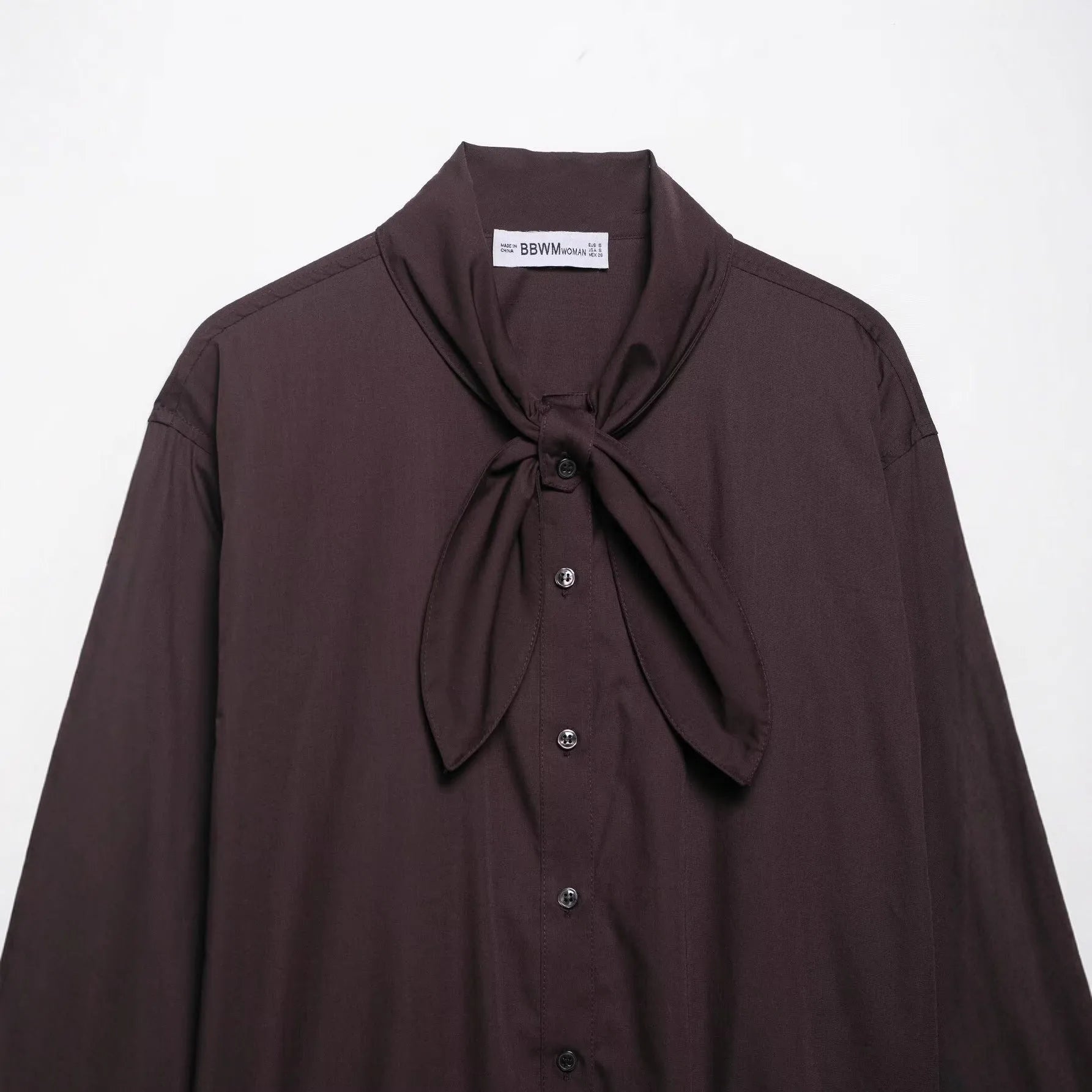 Brown women's loose fit poplin shirt with long sleeves and an integrated bow tie scarf at the neck.