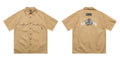 Men's loose fit black embroidered half-sleeve work shirt on a hanger.