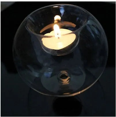 Handmade round hollow glass candle holder in clear glass on wooden surface
