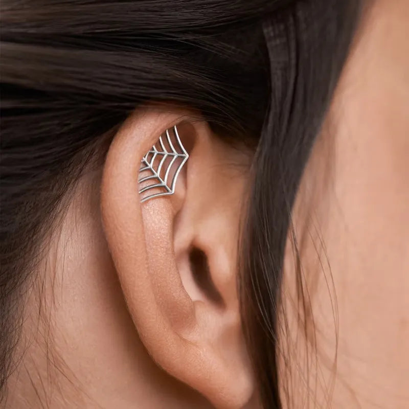 Metal spider web stud earrings in electroplated gold or silver finish, geometric mesh design.