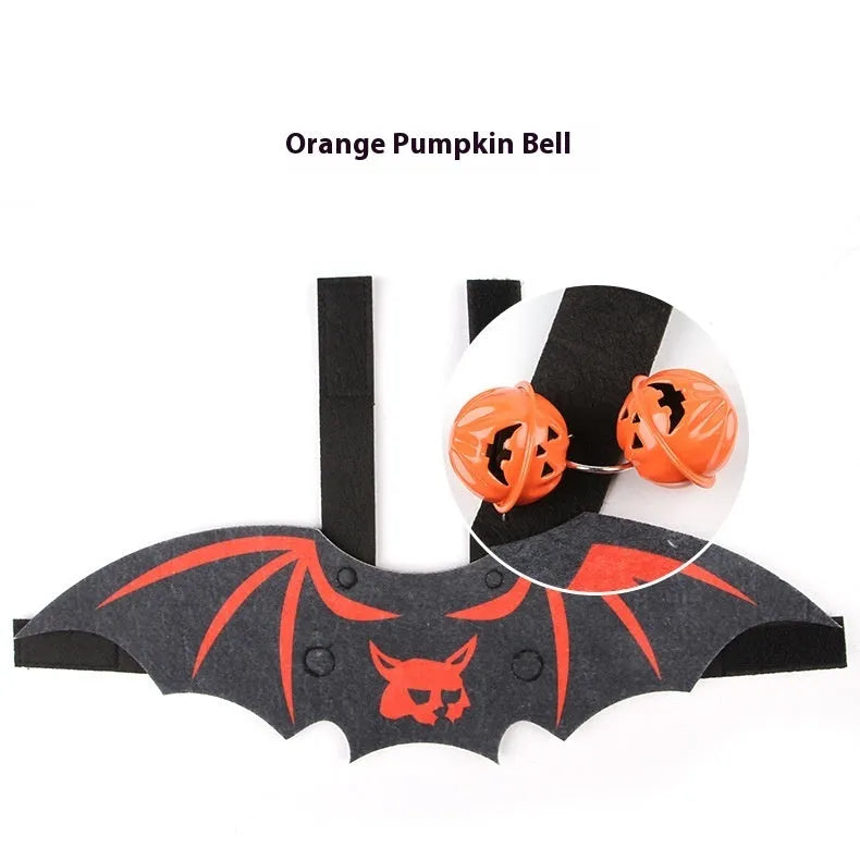 Black cat wearing an orange felt batwing Halloween costume with bell.