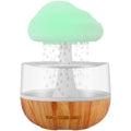 White cloud-shaped humidifier with night light and water flow display on wooden surface