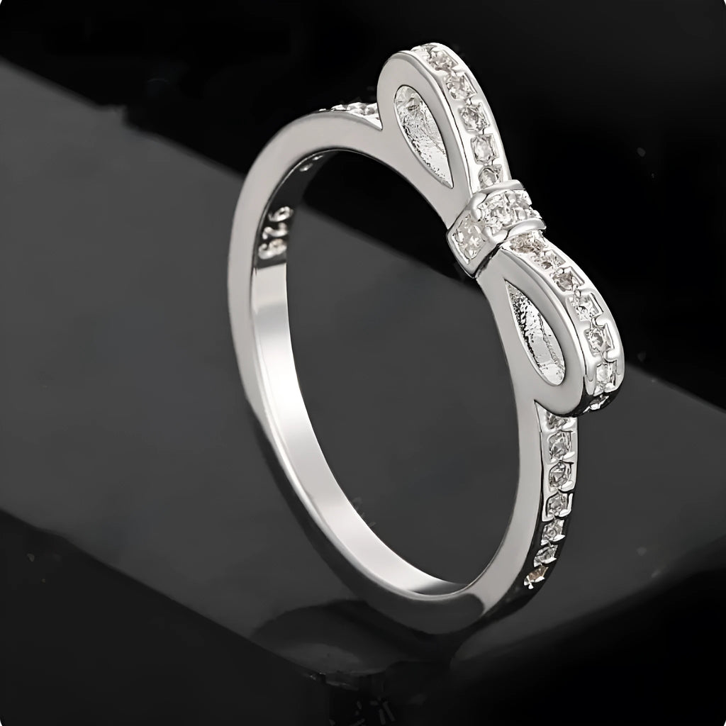 Silver couple style ring with bow shape decorated with rhinestone and zircon crystals.