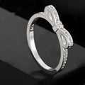 Silver couple style ring with bow shape decorated with rhinestone and zircon crystals.