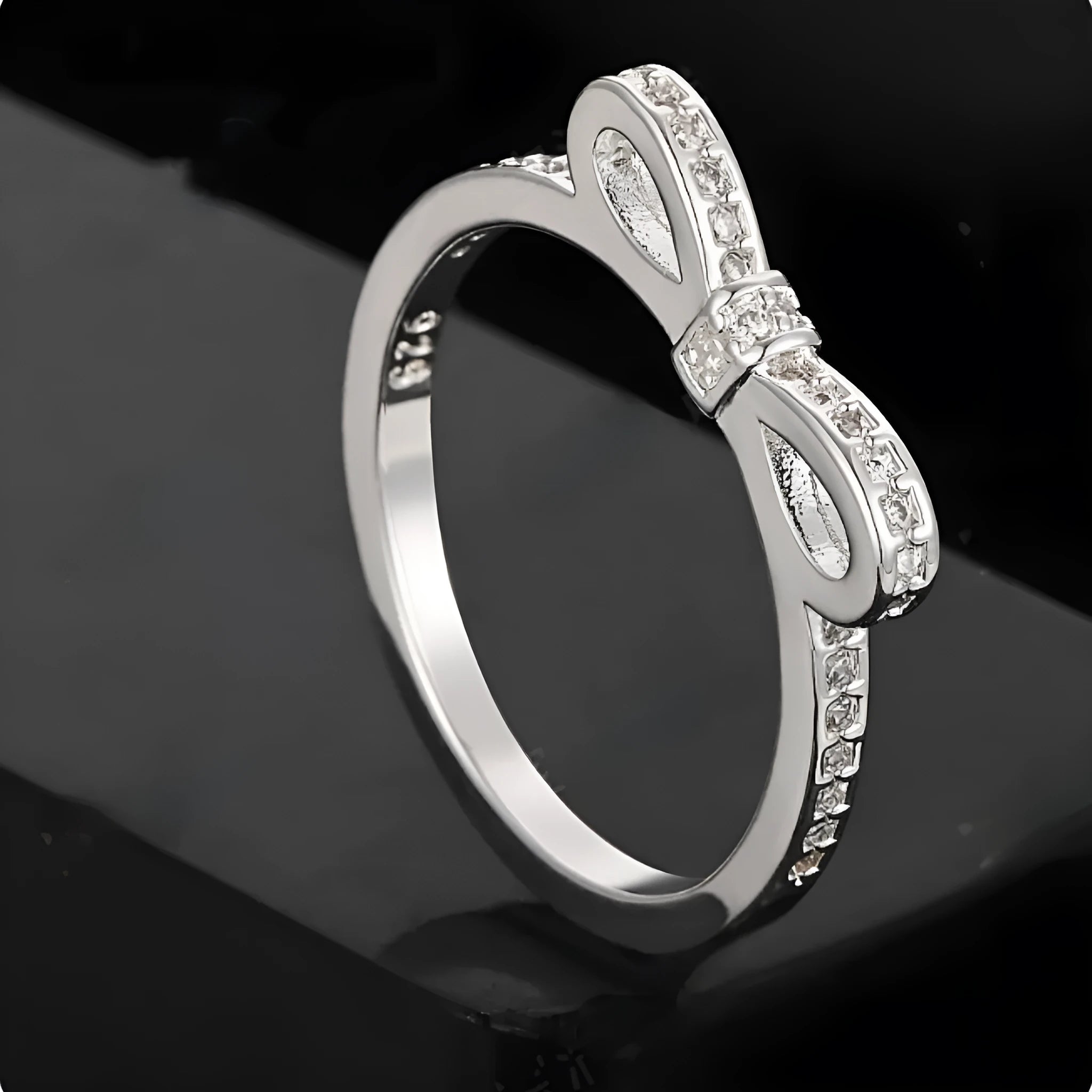 Silver couple style ring with bow shape decorated with rhinestone and zircon crystals.
