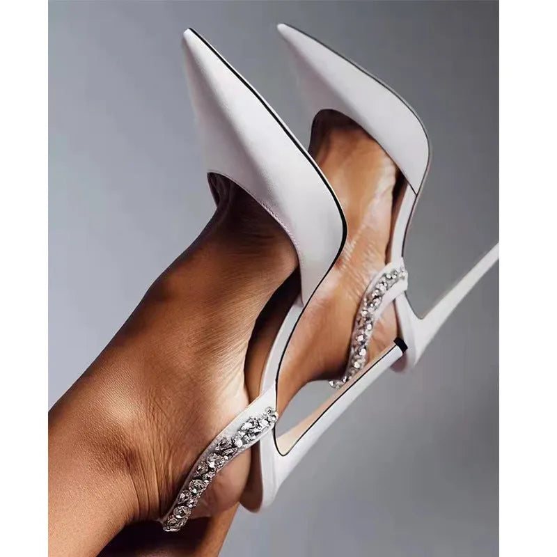 Women's black patent leather pointed toe high heel sandals with side rhinestones and an ankle strap.