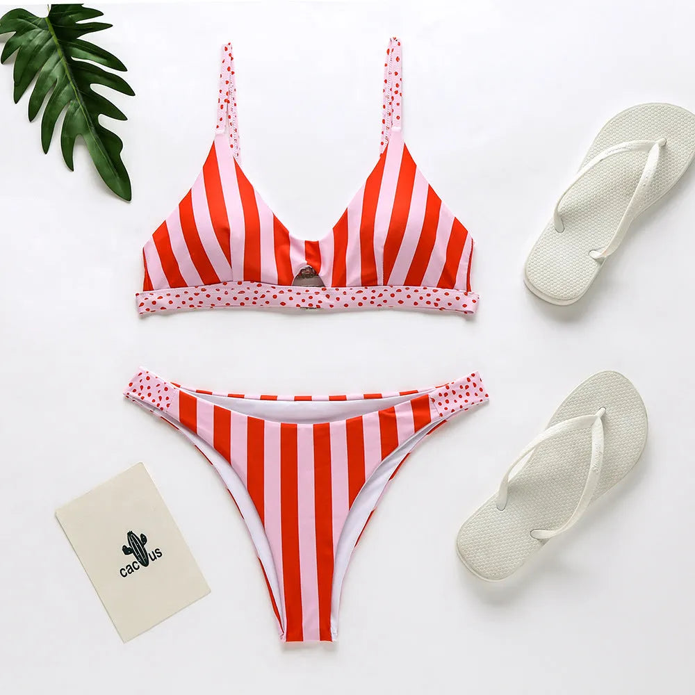 Women's black and white polka dot polyester bikini swimsuit laid flat, showing top and bottom pieces.