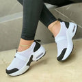 Women's white mesh flat sneakers with a round toe and rubber sole.