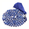 Long agate and amethyst gemstone tassel necklace with geometric pendant on a model.