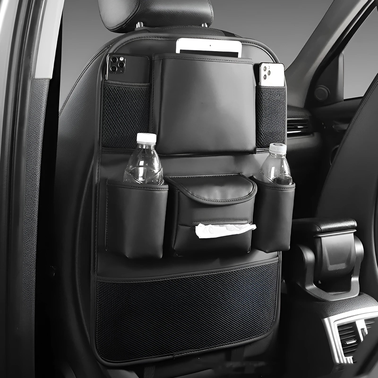 Leather car seat back storage bag in black, hanging behind a car headrest.