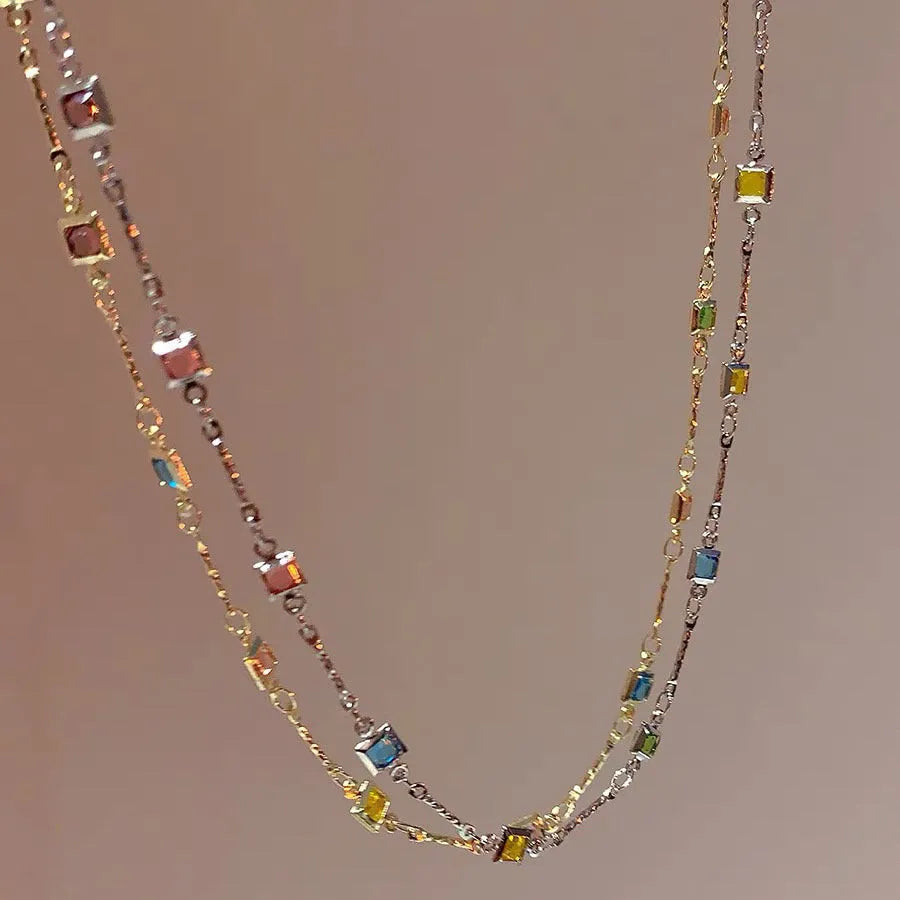 Fine geometric clavicle chain necklace with square artificial crystal links in gold or white K plating.
