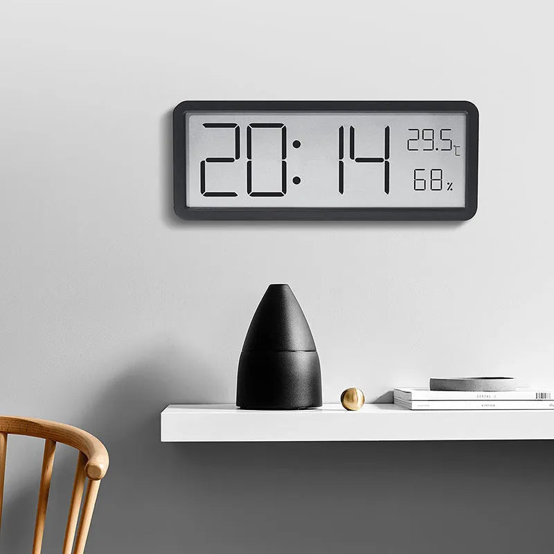 Simple large screen temperature and humidity clock in plastic with Nordic style, black colour, on a desk.