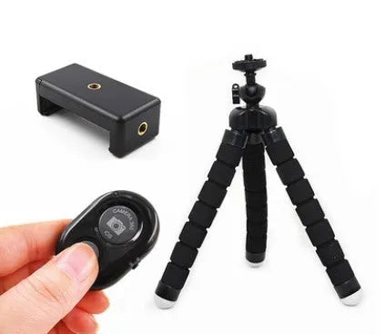 Black flexible octopus tripod with wrapped legs holding a smartphone next to a camera.