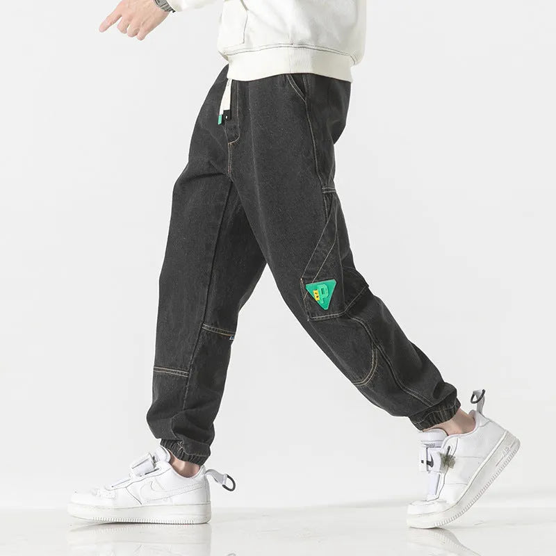 Men's loose-fit tapered cotton trousers showing tapered leg and mid-waist design in black colour