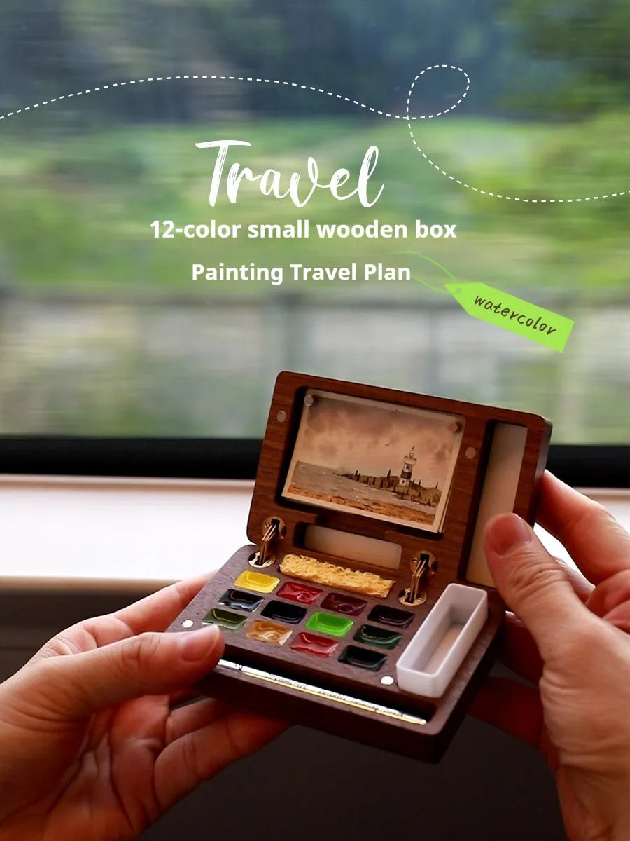 Mini walnut wooden box open to show watercolour paint pans in a portable artist travel set.