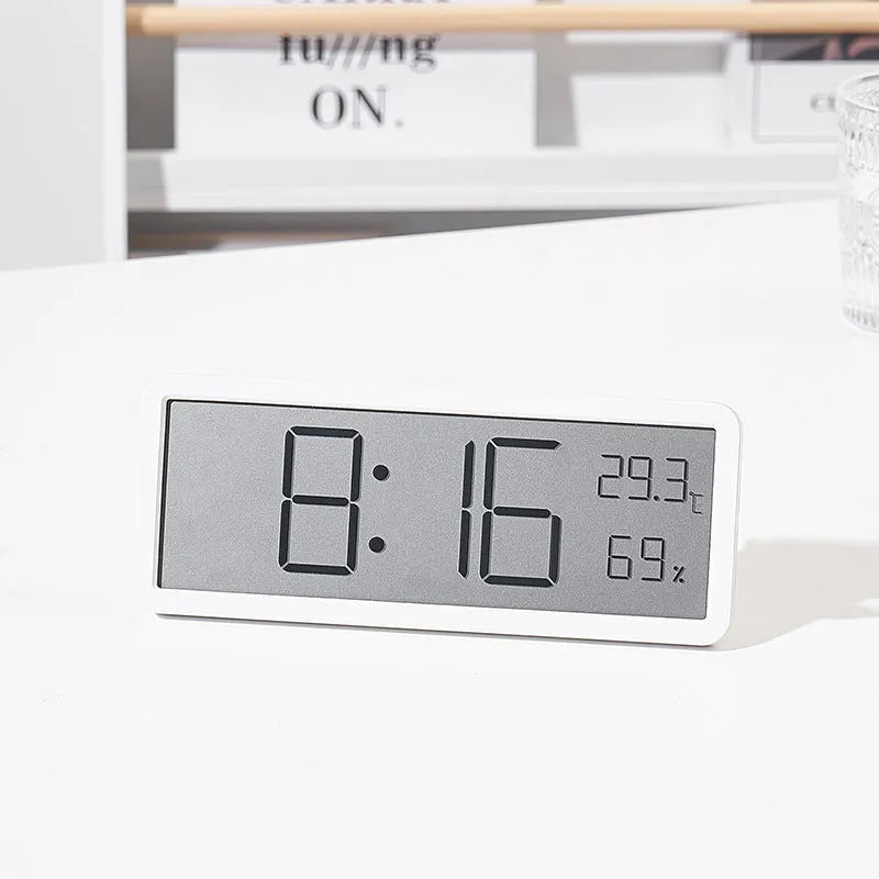 Simple large screen temperature and humidity clock in plastic with Nordic style, black colour, on a desk.