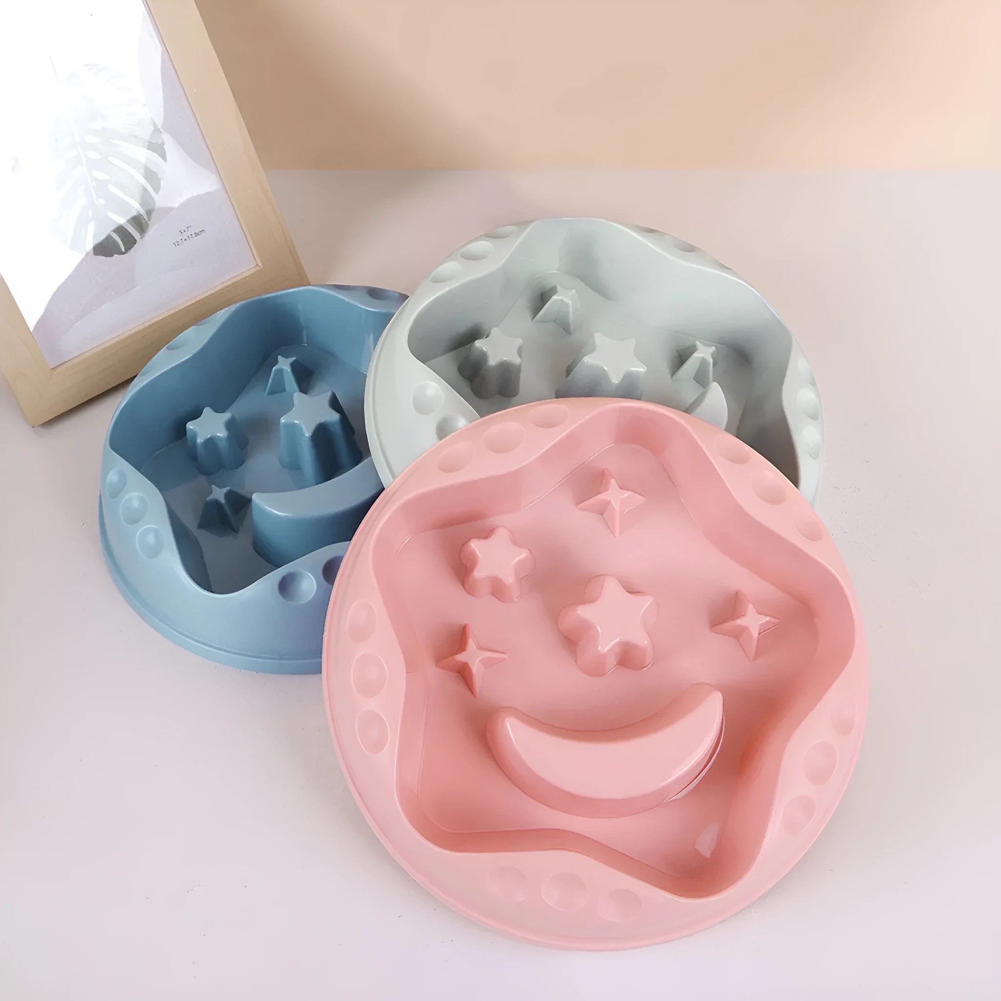 Blue slow feeder dog bowl with moon and star wing design and internal maze pattern.