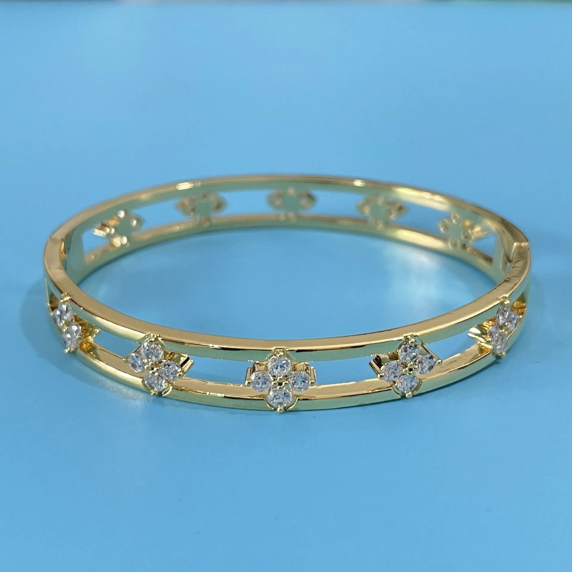 Gold and silver women's bracelets with hollow design and four-leaf clover zircon charms.