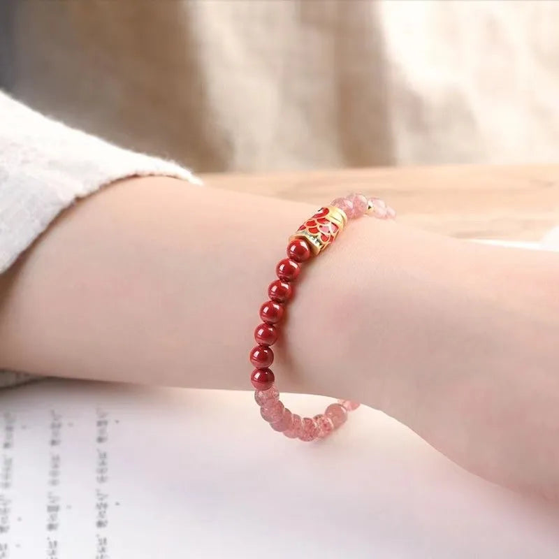 Purple and pink cinnabar and strawberry quartz beaded bracelet with peach blossom and koi designs.