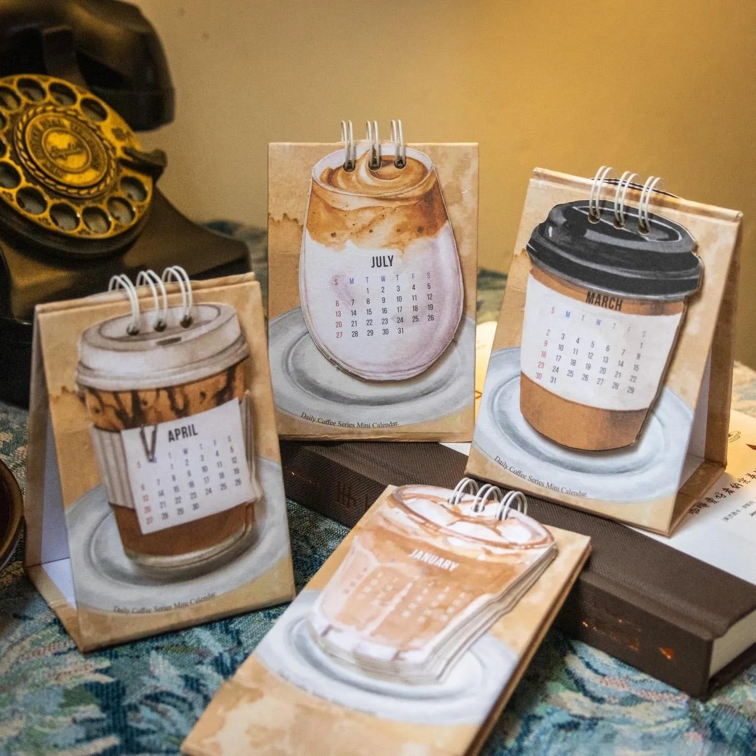 Mini coffee desk calendar 2025 with four design options on small desk surface