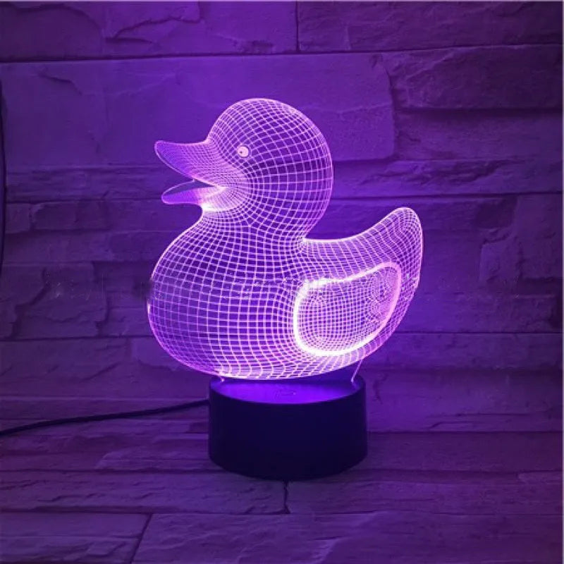 Little yellow duck 3D night light showing seven colour options and remote control on a desk