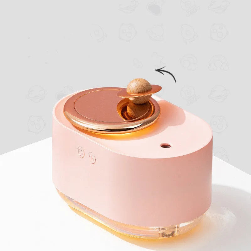 Green rotating planet-shaped car humidifier with night light on a desk next to a USB cable.