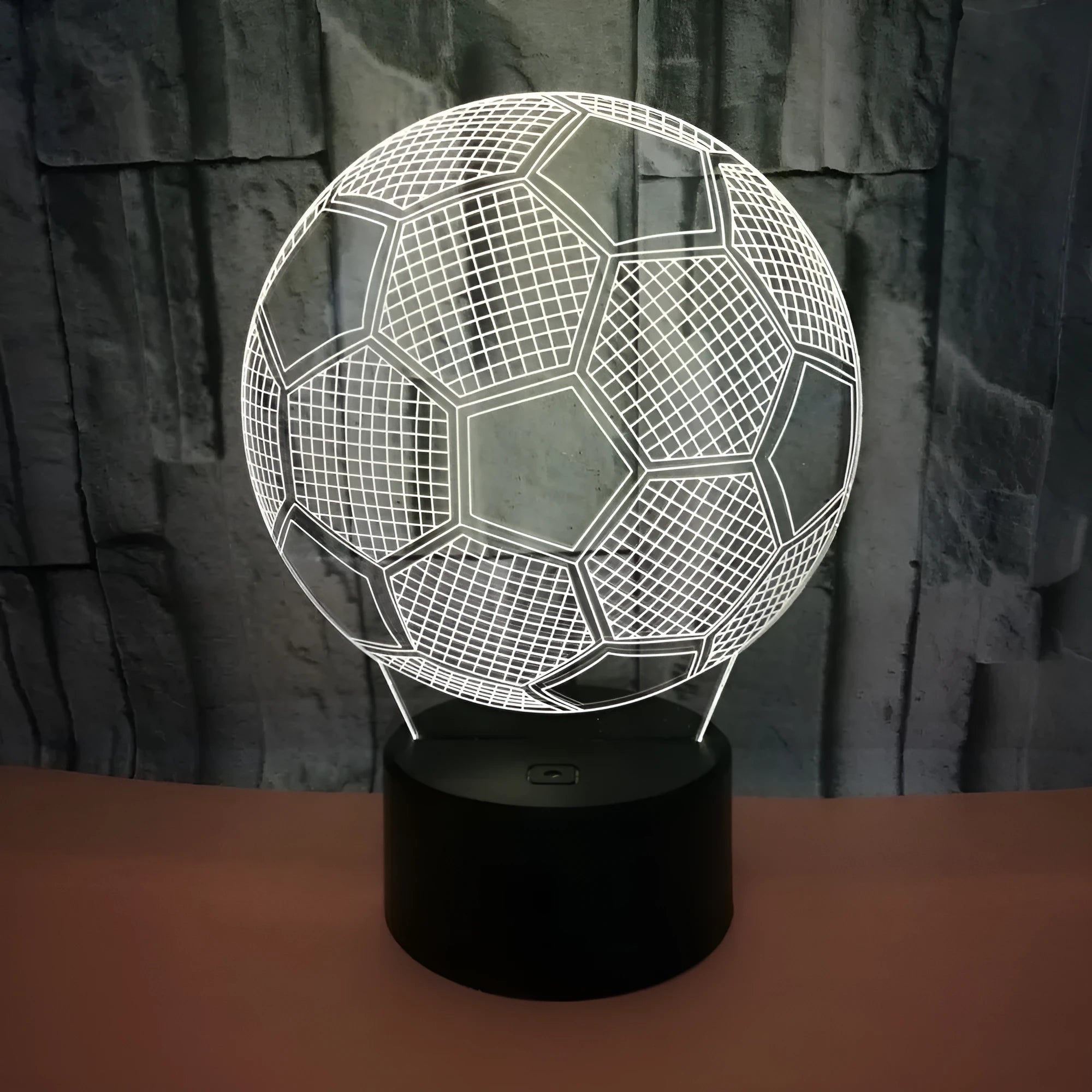 3D football-shaped night light showing multicolour illumination on acrylic surface