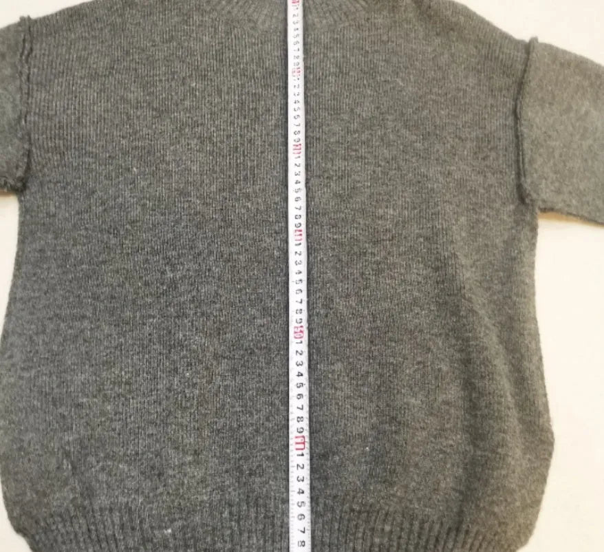 Women's dark grey acrylic knit sweater and trouser suit with a side-slit design on the top.