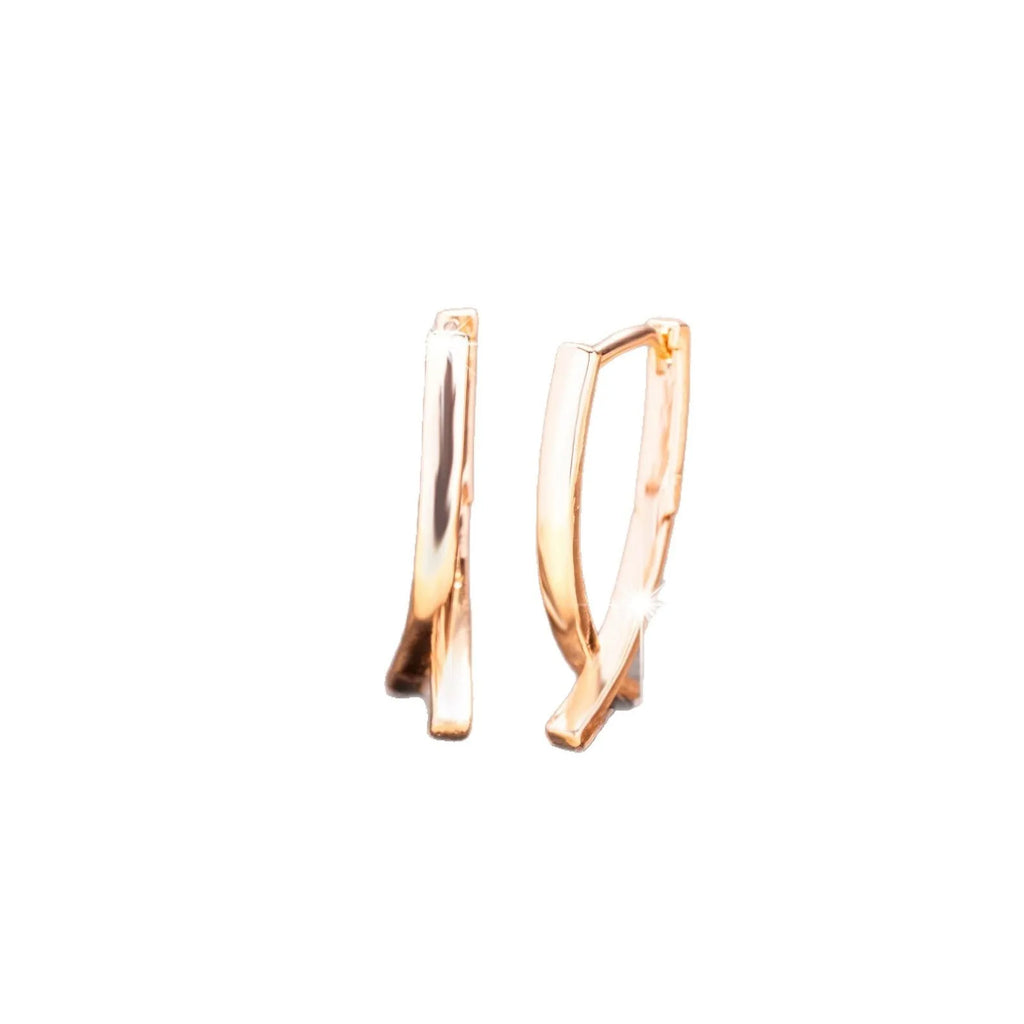 A pair of rose gold-coloured copper earrings in a detailed cross shape.