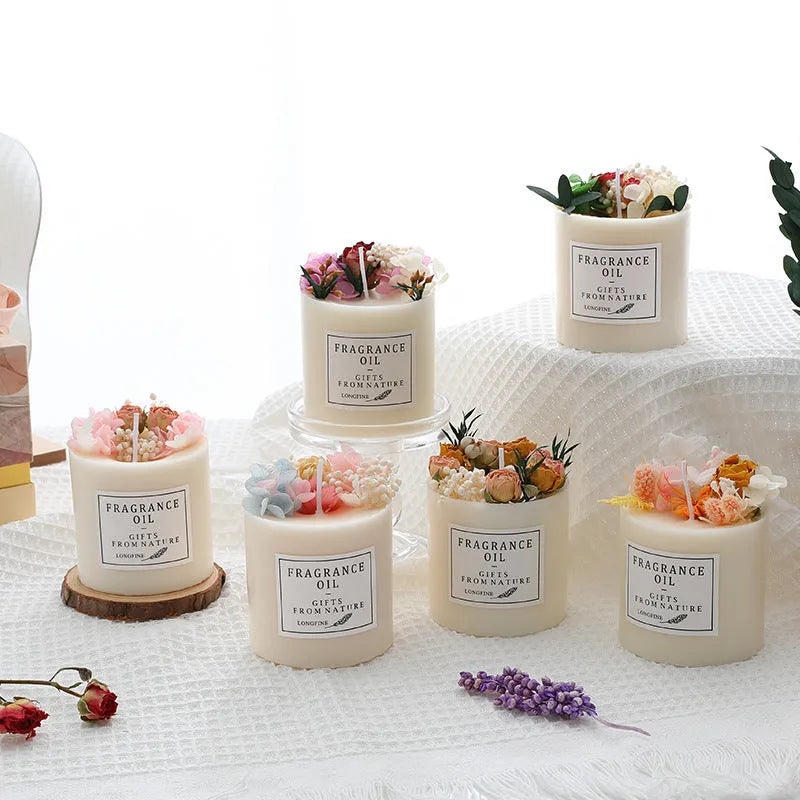 Decorative scented candle with dried flowers inside, shown with wooden chip base and gift box packaging.