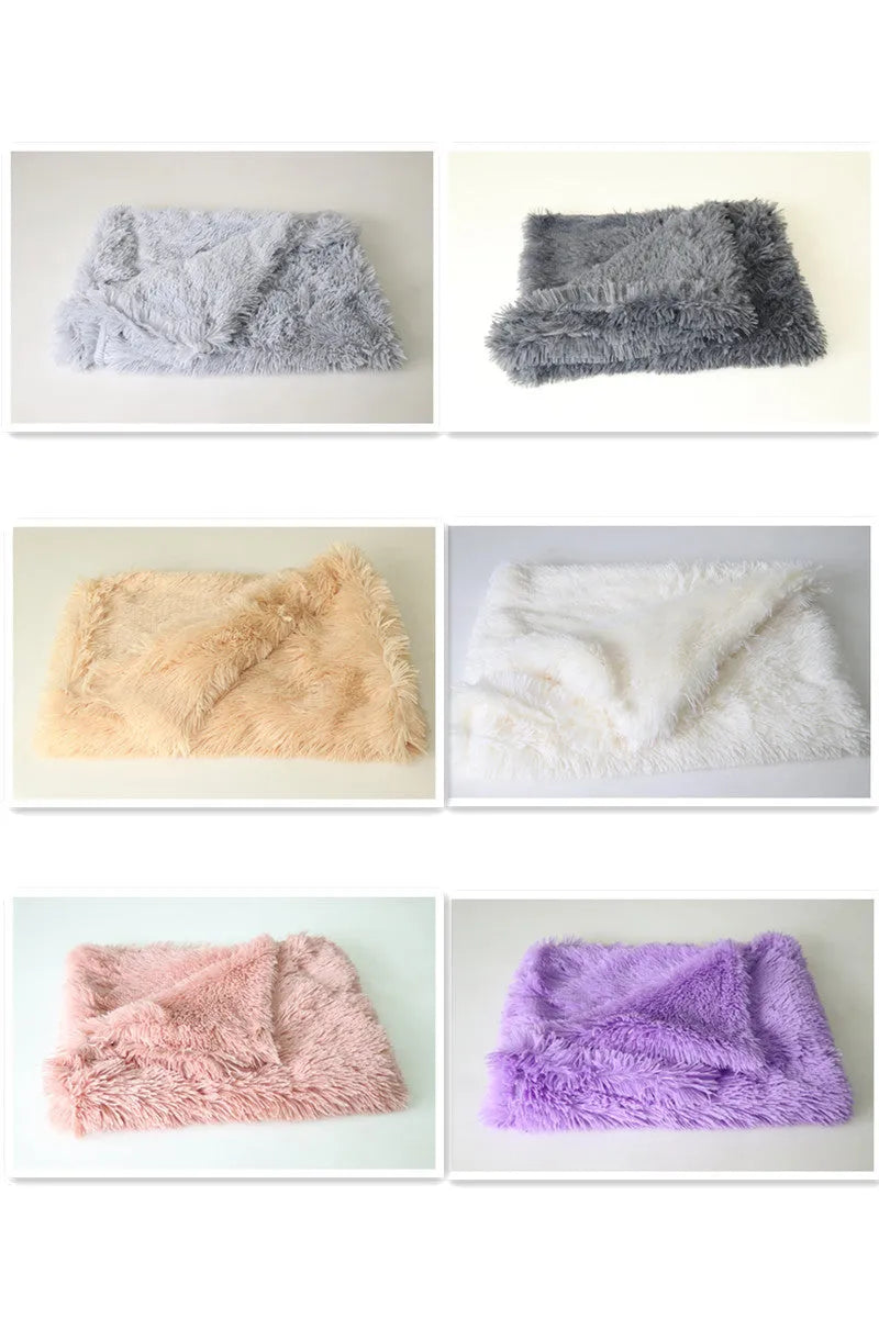 Soft grey long plush pet blanket for dogs on a wooden floor next to a kennel.