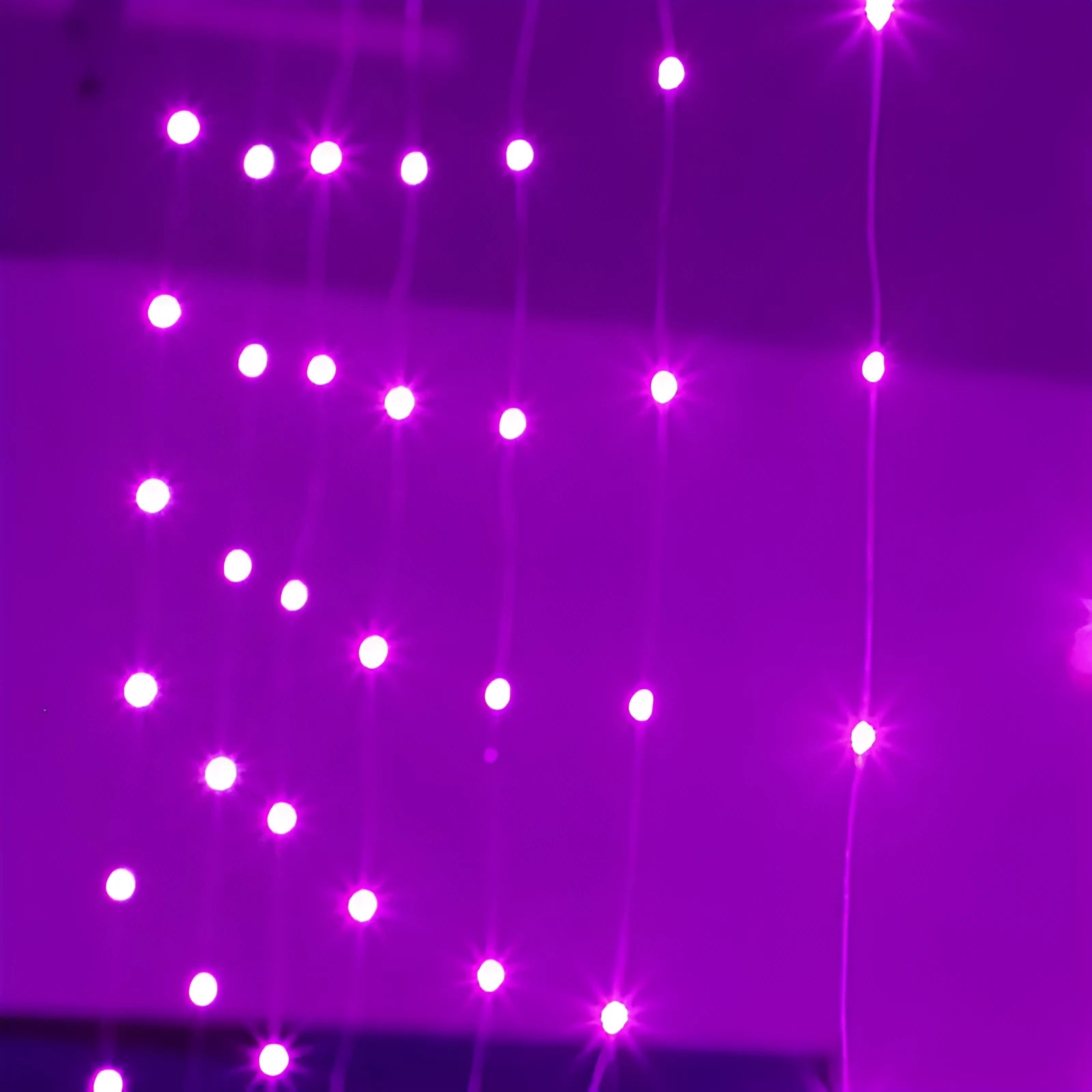 Copper curtain fairy lights with multiple LED beads, showing blue, purple, and white colour options hung in a decorative drape.