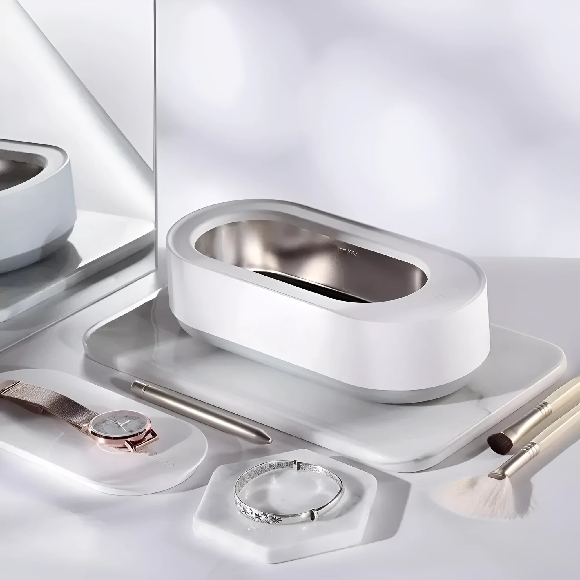 White portable ultrasonic cleaner with stainless steel tank and a single control button.
