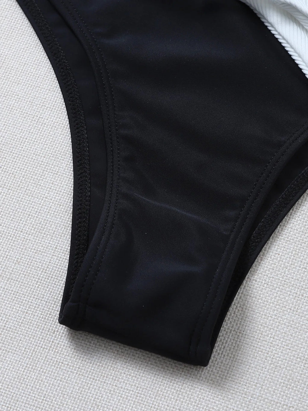 Solid colour bikini with chest pad in black and white, polyester fabric, front view