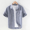 Men's raw jute coloured linen shirt with a square collar and short sleeves on a hanger.