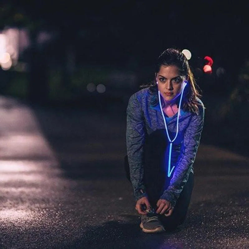 Blue Magic Light LED earphones with glowing stems, 3.5mm plug, and inline remote on a dark background.