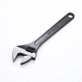 High carbon steel adjustable open-end wrench with blackened finish on a grey background.
