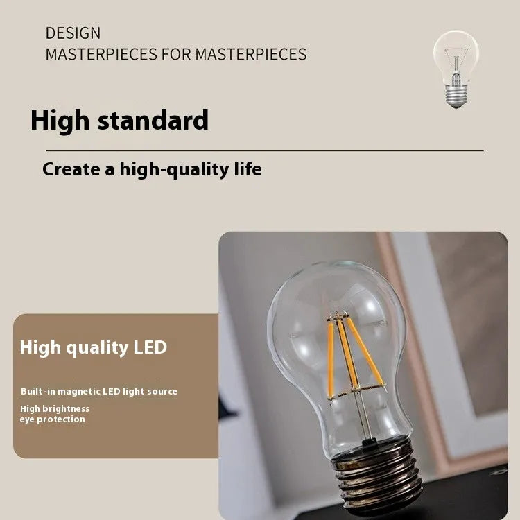 Iron art suspension bulb night lamp on a black wood grain base for desktop decoration.