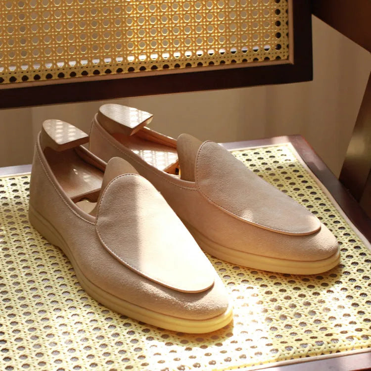 Men's brown genuine leather handmade loafers on a white background, showing the low-cut slip-on design and textured sole.