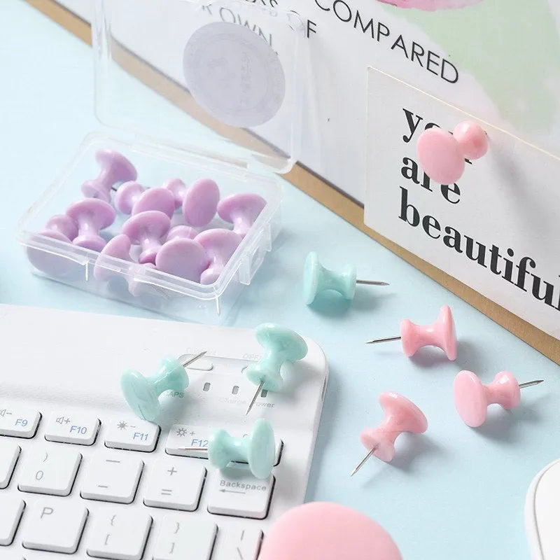 Plastic push pins in cherry blossom pink, mint green, and lavender, showing large and small sizes on a corkboard