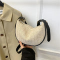 Women's straw woven crossbody bag showing woven texture and internal phone pocket