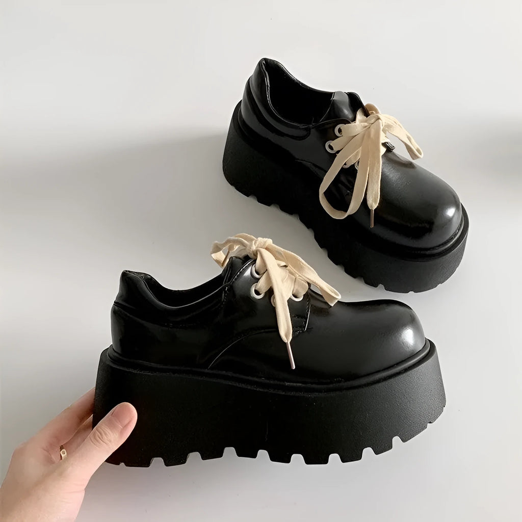 Women's matte black lace-up heeled shoes with thick rubber sole and block heel on a plain background