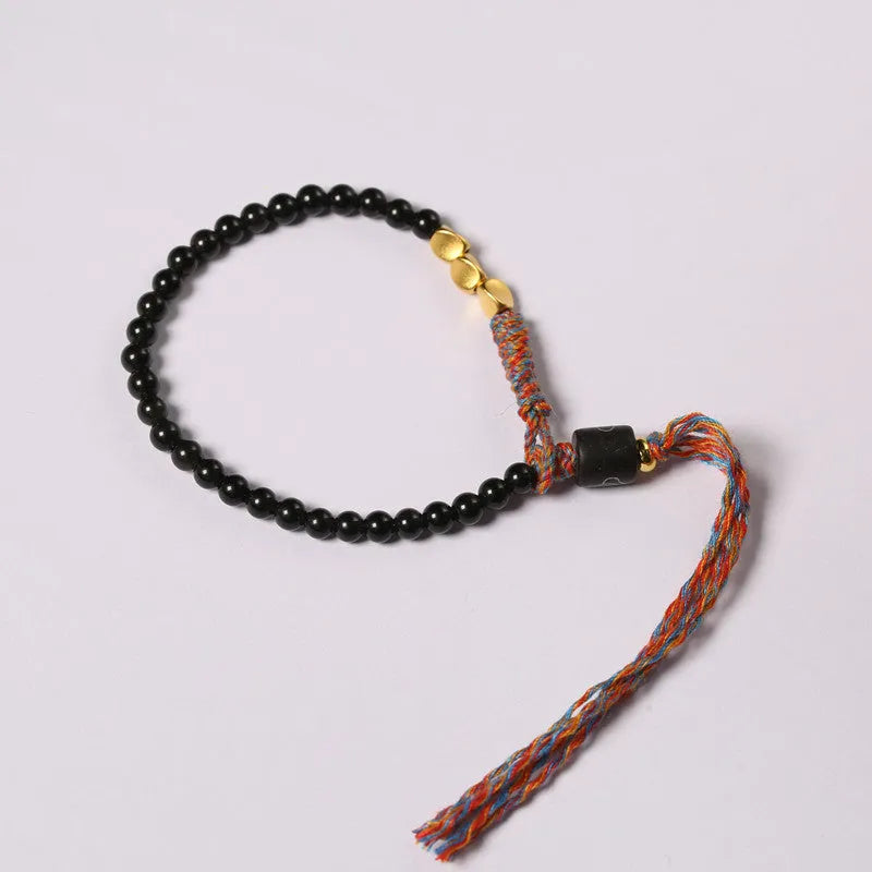 Hand-woven obsidian carrying strap bracelet showing textured weave and 4mm width