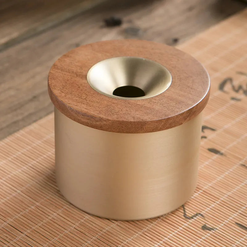 Retro brass ashtray with wooden lid showing centre hole design for ash collection