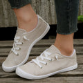 Creamy white low-top women's casual sneakers with a fabric upper and rubber sole.
