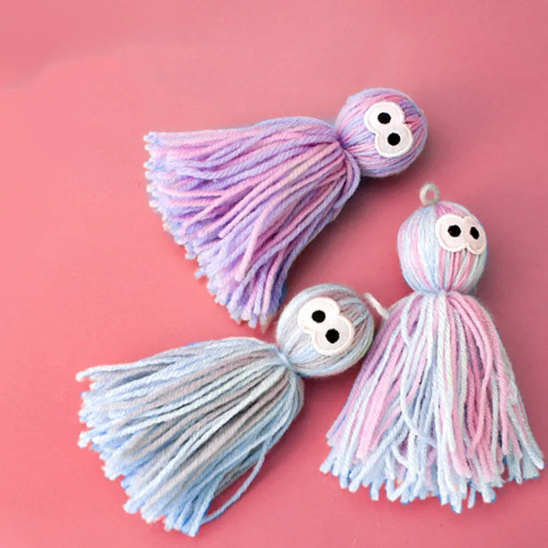 Blue grey hanging wool ball cat toy and teaser stick on a plain background.