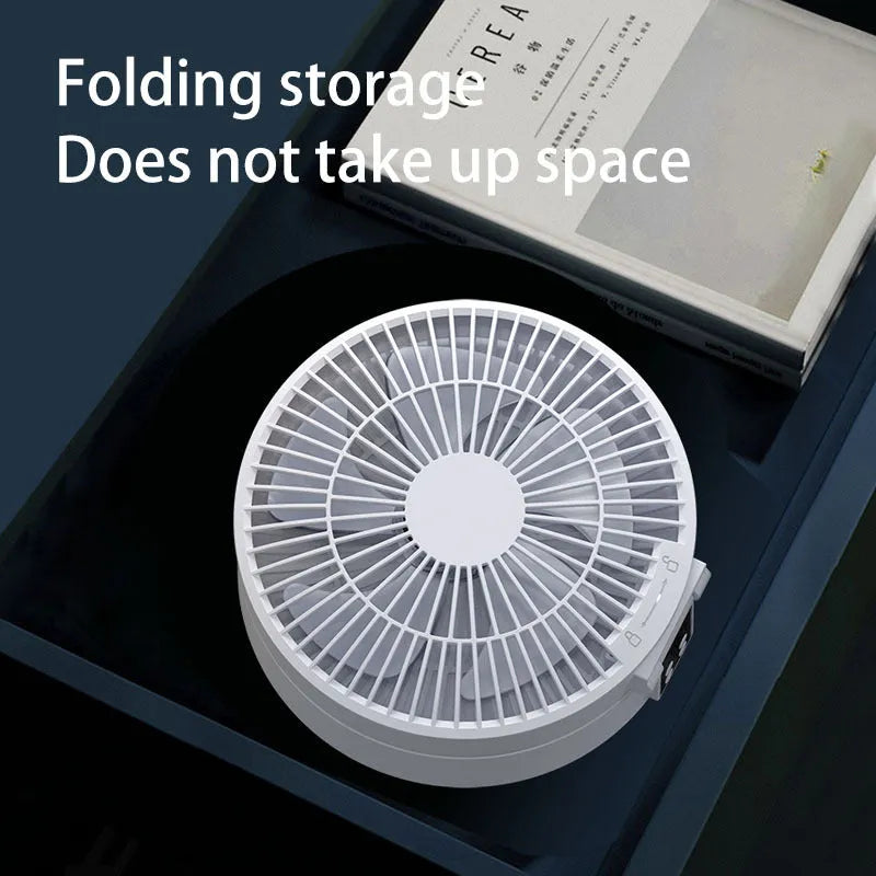 White portable rechargeable folding fan with remote control and warm night light on a desk